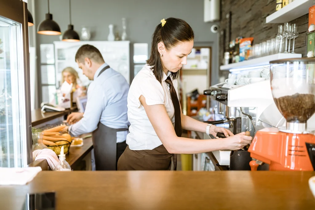 Two barkeepers diligently working behind the counter, highlighting diverse work experiences that can be featured in a resume. Learn how to write a resume with Advanced Employment Services.