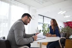 A candidate smiling during a job interview with a recruiter, showcasing the process of making a good impression with guidance from Advanced Employment Services.