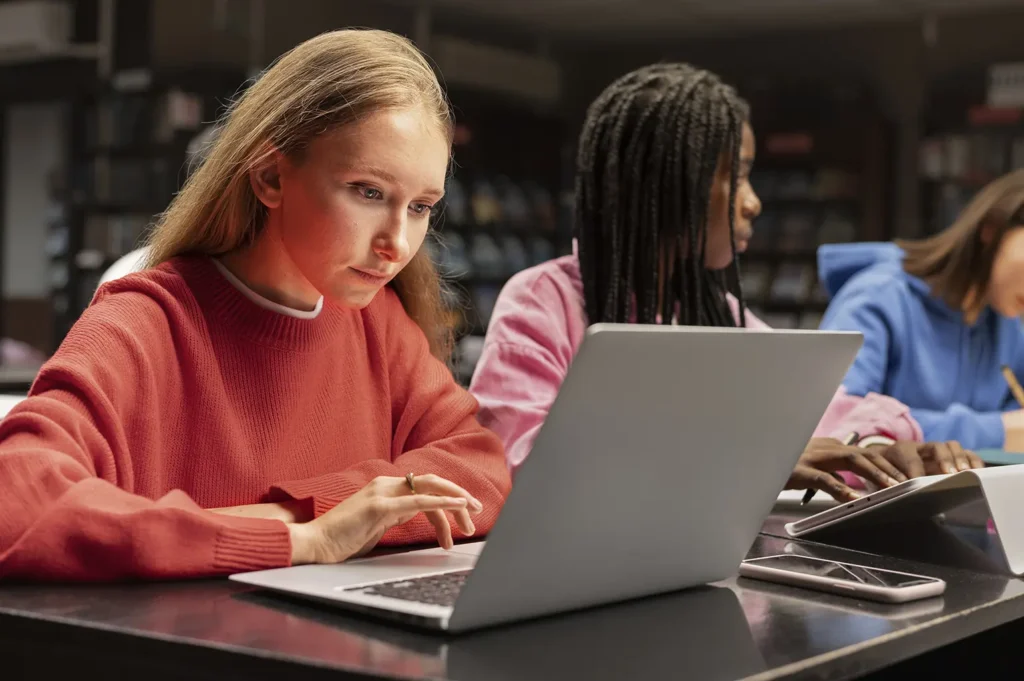 Focused students working on their career planning and goals in a library, emphasizing the guidance provided by Advanced Employment Services in career development.