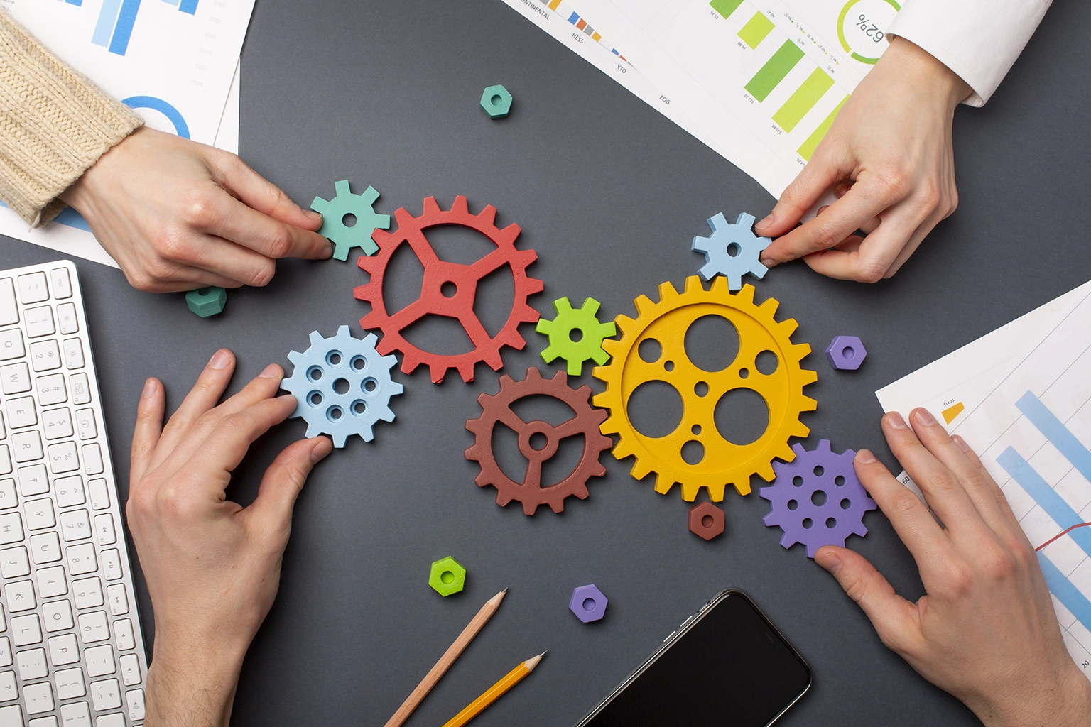 Close-up of hands assembling colorful gears, symbolizing the interconnectedness of career development and professional growth with Advanced Employment Services.