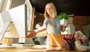 Young businesswoman setting up her workspace, reflecting modern workplace trends in flexible work environments. Advanced Employment Services insights on business adaptation.